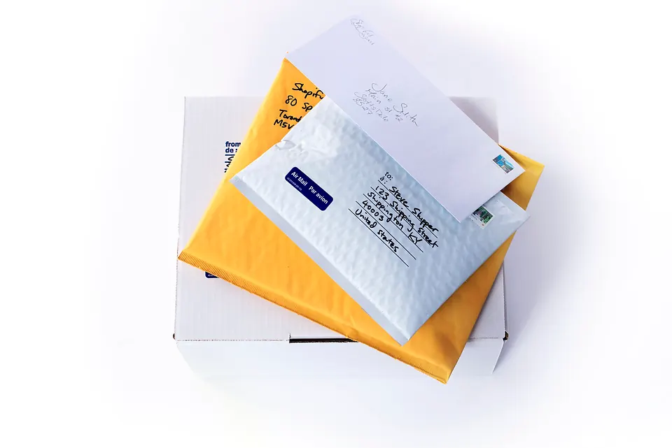 A stack of addressed parcels and yellow padded envelopes