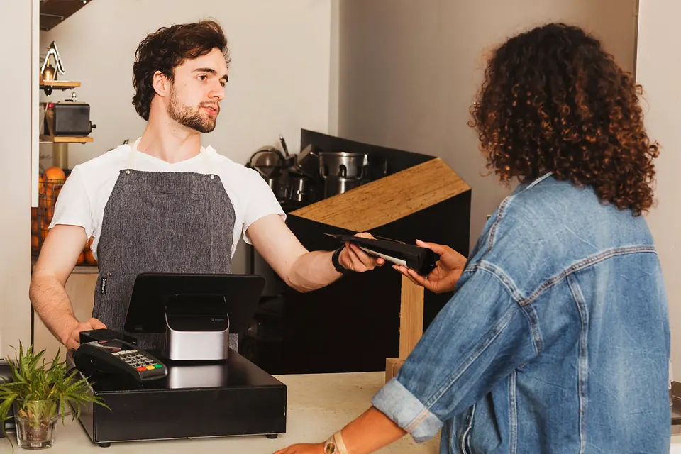 A customer paying by card at a café counter